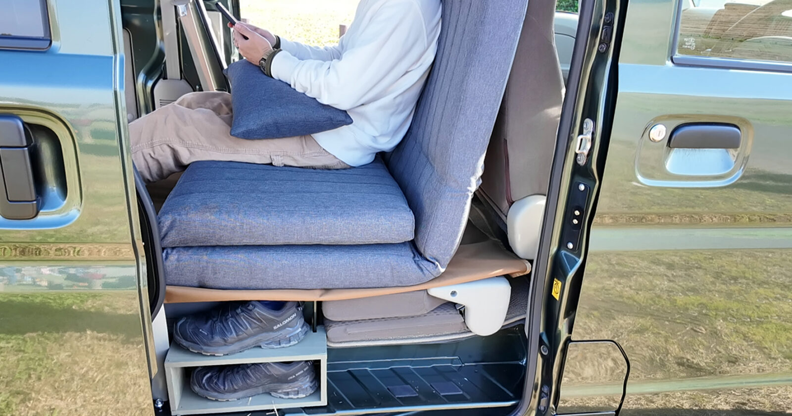 エブリイDA17Vの荷室にソファベッドを置き、リラックスしている様子